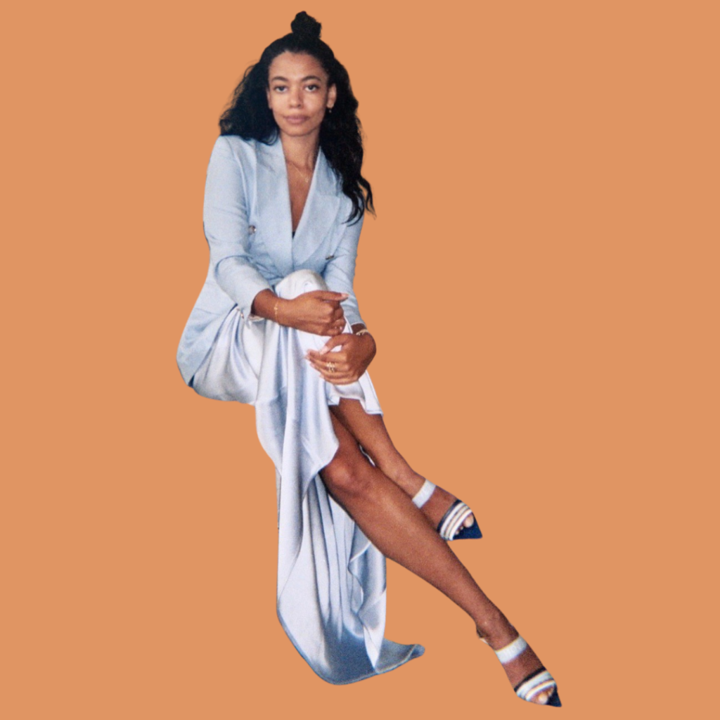 Aurora James in silver dress and orange background