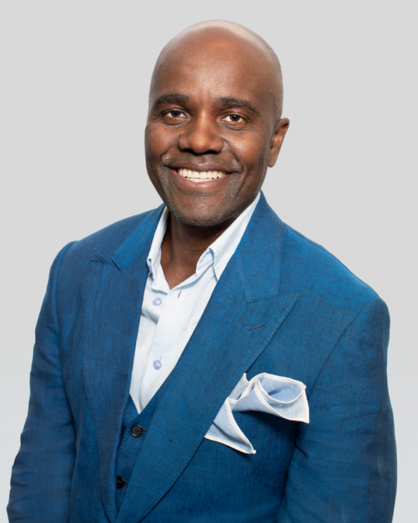 Smiling Wes Hall in blue suit and white pocket square