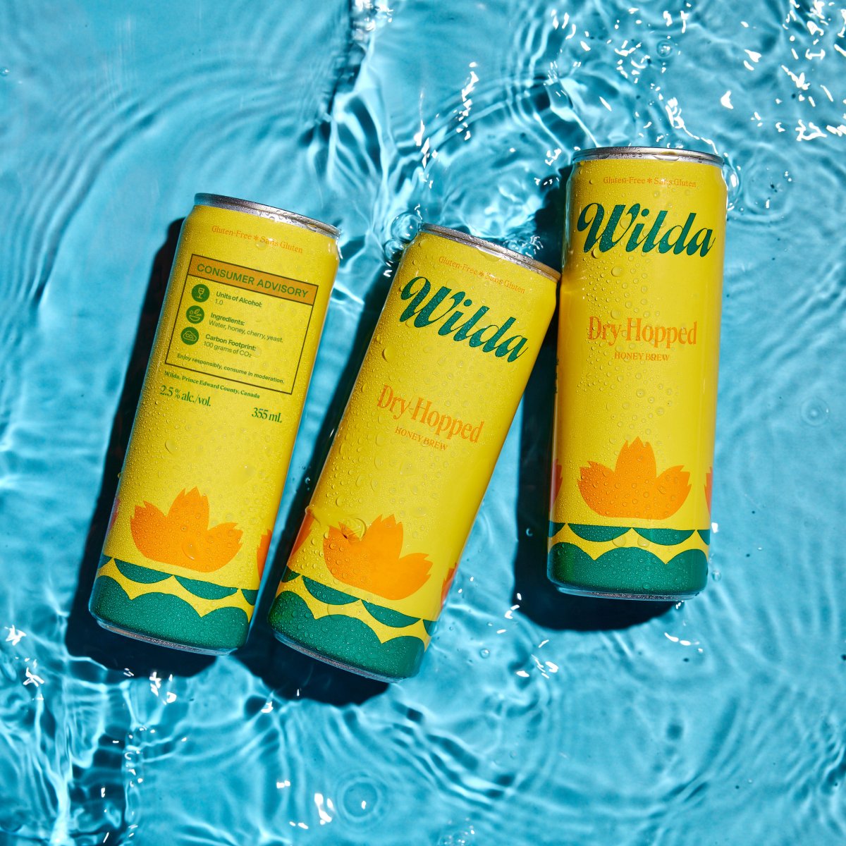 Three yellow cans in water showing alcohol advisory label.